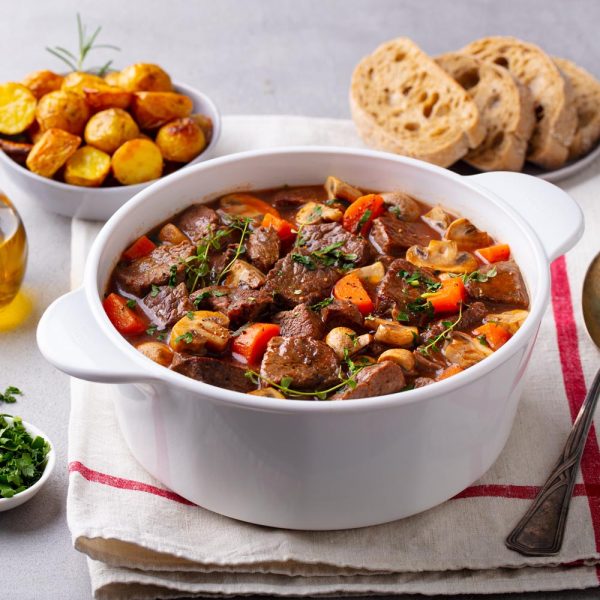 beef bourguignon stew with vegetables. grey background. copy space.